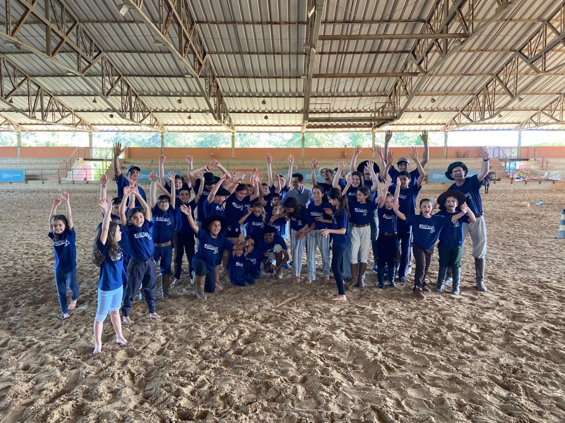 Grupo de crianças e adultos reunidos e comemorando em uma arena